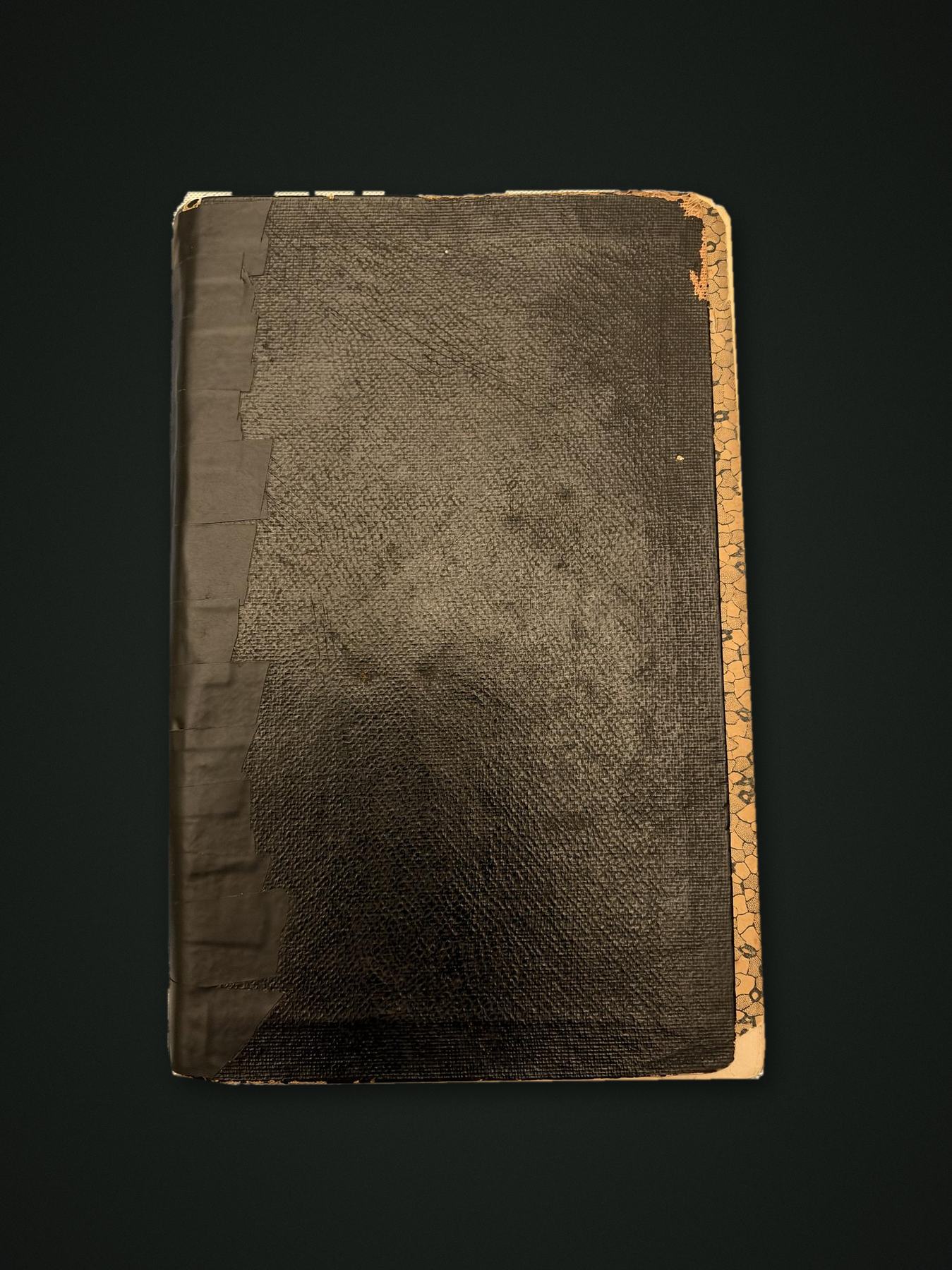 The minute book, closed: black cloth boards, spine held with tape, marbled page edges