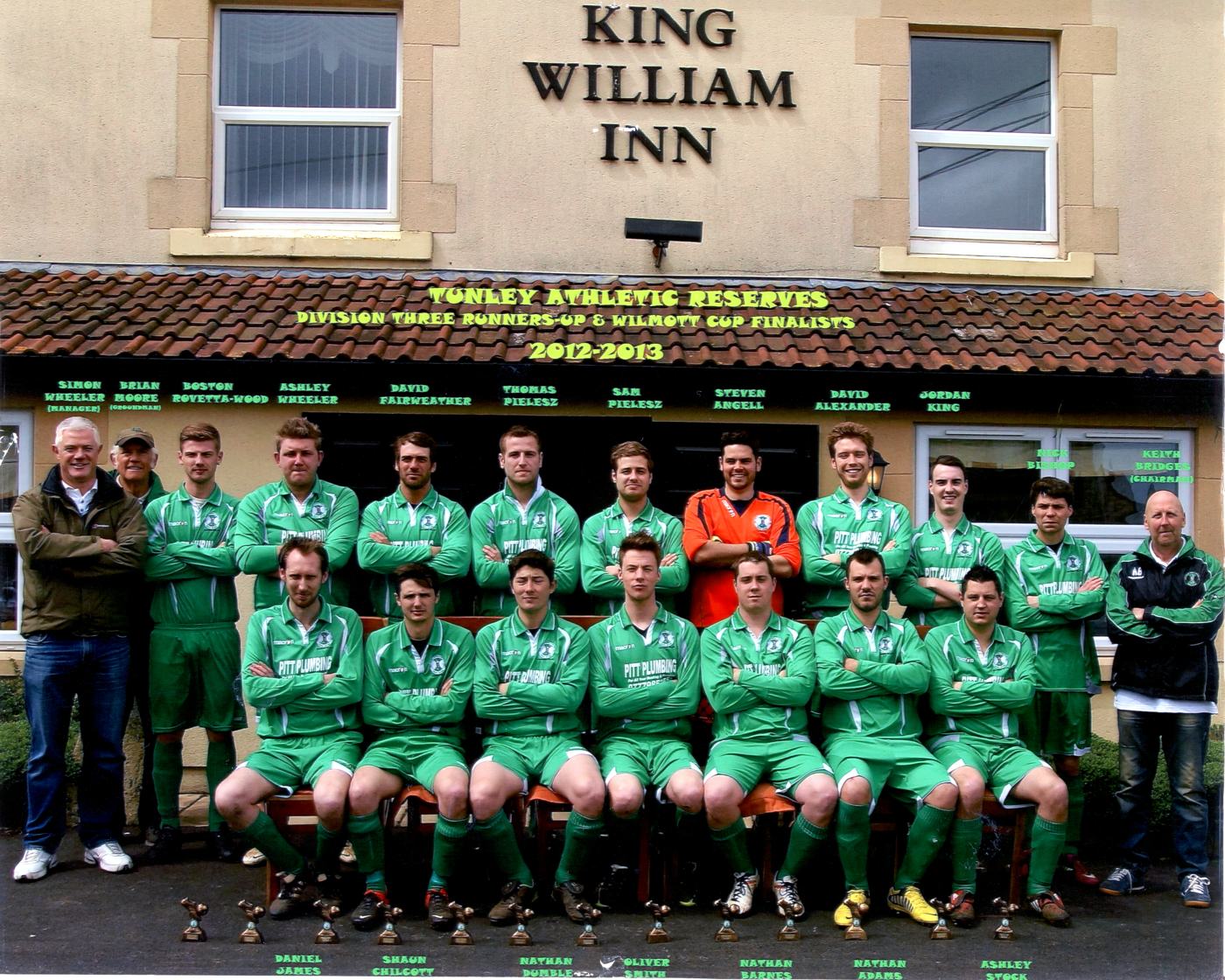 Tunley reserves in green kit outside the King William Inn, with a banner reading Tunley Athletic Reserves 2012-2013