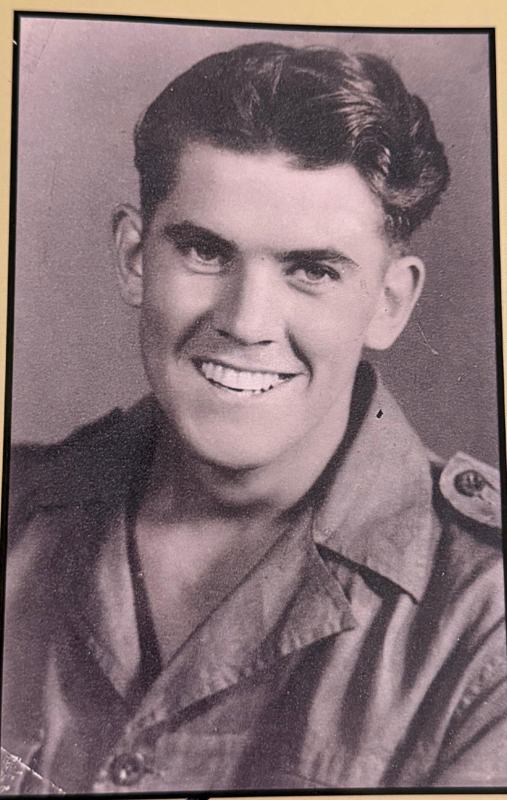 Black and white portrait of a smiling young man in an army shirt, from the cover of Bryan Moore's book